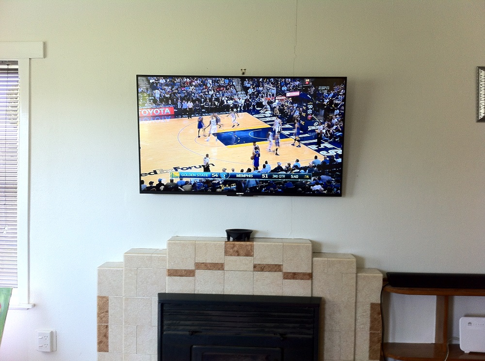 tv mounted above a fireplace in glen innes